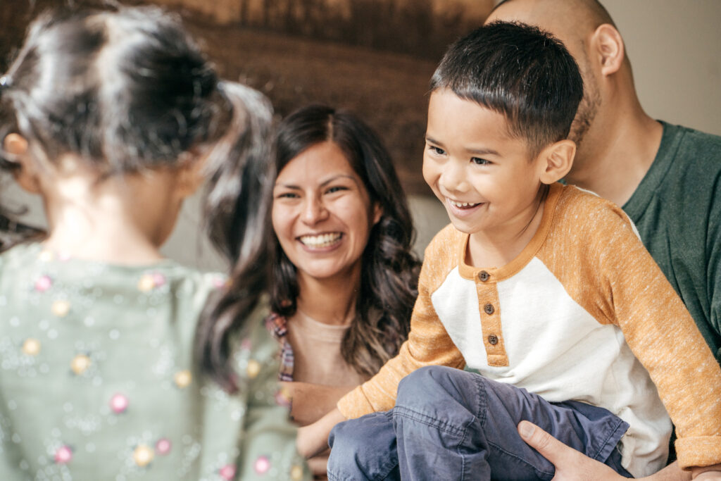 Laughing family with two kids Hispanic Family laughing together